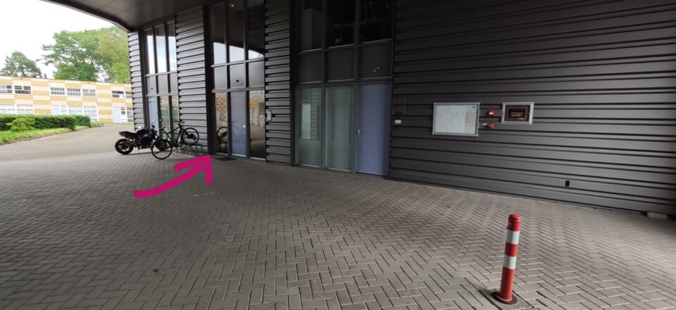 Under the overhang, an arrow to our door past the parked bikes